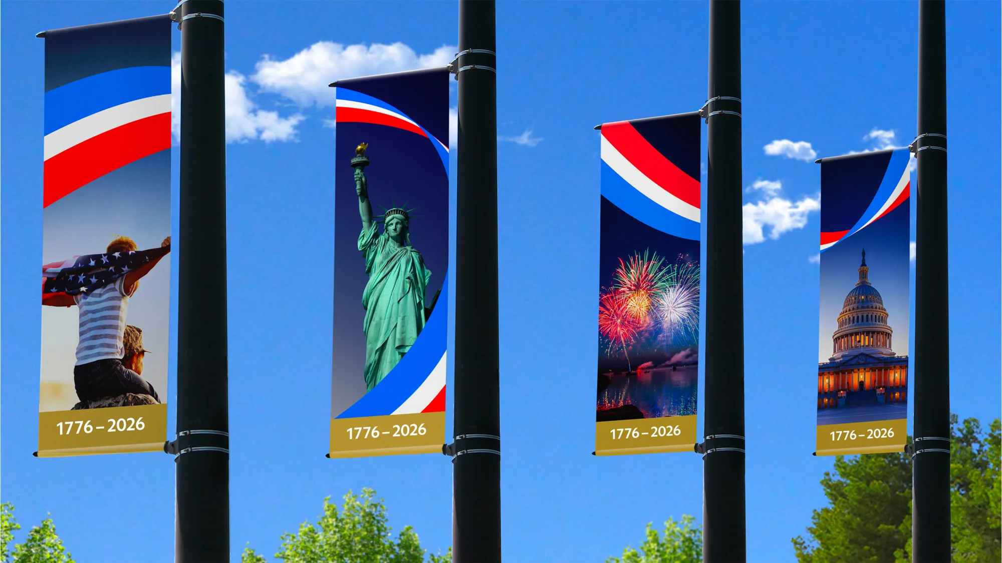 Four street-pole banners against a blue sky, each topped by the America250 ribbon mark over a photo of a flag-waver, the Statue of Liberty, fireworks and the US Capitol, all dated 1776 to 2026.